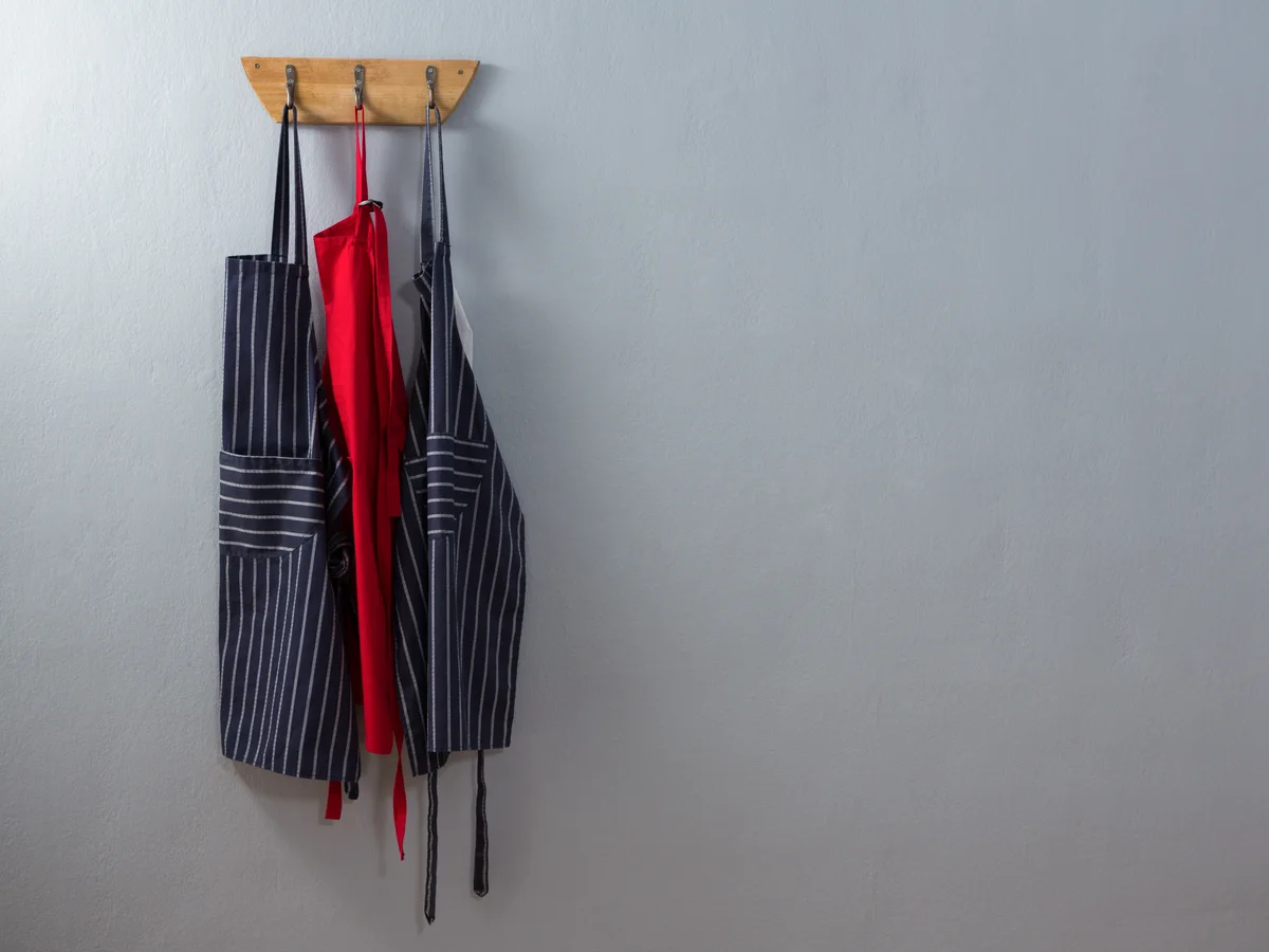 Aprons hanging from hooks on a wall