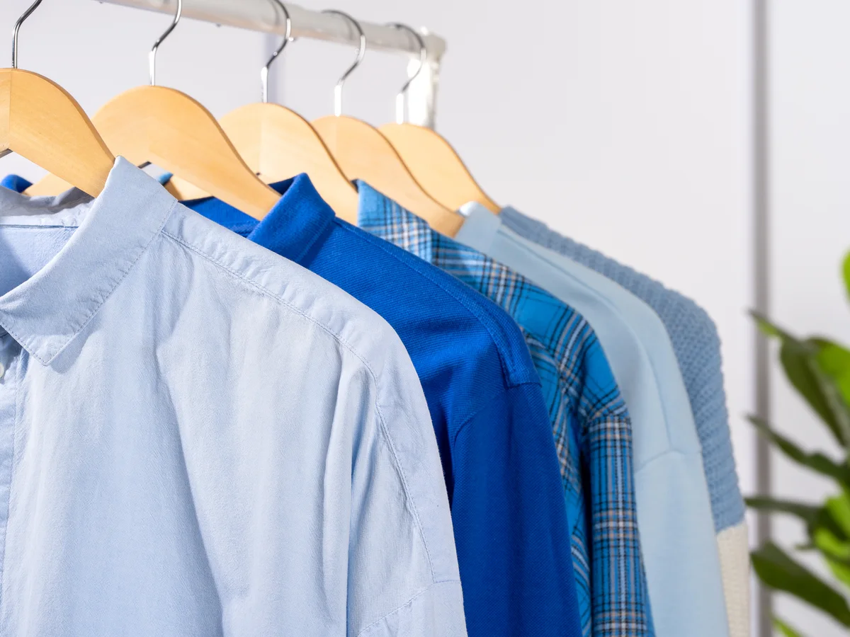 Blue and white shirts on wooden hangers